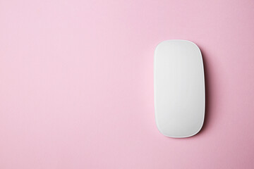 One wireless mouse on pink background, top view. Space for text