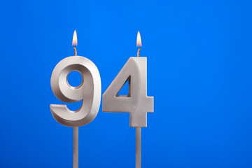 Birthday candle number 94 - Celebration card on blue background