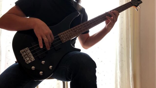 Chico tocando m&uacute;sica con un bajo el&eacute;ctrico