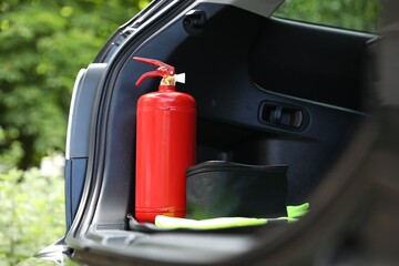 Red fire extinguisher in trunk. Car safety equipment © New Africa