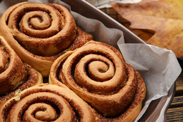 Baking dish of tasty cinnamon rolls on table, closeup