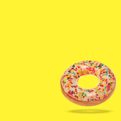 Stylish inflatable donut shaped ring in air on yellow background. Space for text
