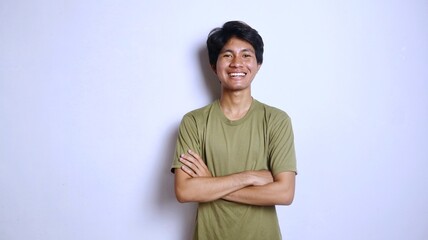 Handsome young Asian man smiling with crossed arms gesture