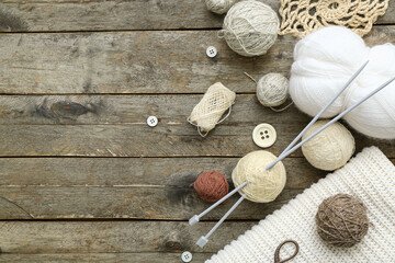 Yarn balls and knitting accessories on wooden background