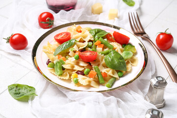 Plate with tasty pasta primavera on white background