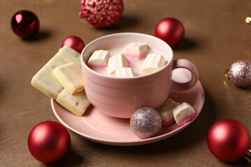 Cup of hot chocolate with marshmallows and Christmas balls on brown background