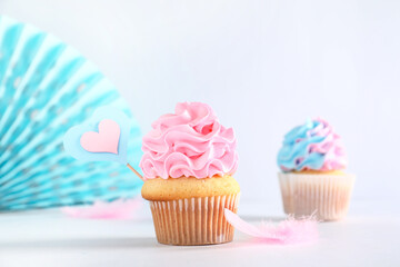 Delicious cupcakes with decorations on table against white background. Gender reveal party concept