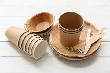 Different eco tableware on white wooden background