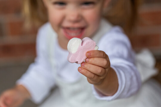 Little girl holding easter bunny shaped marshmallow