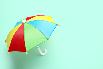 Mini colorful umbrella on green background © Pixel-Shot