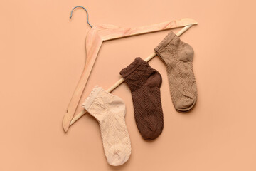 Hanger with basic color socks on beige background