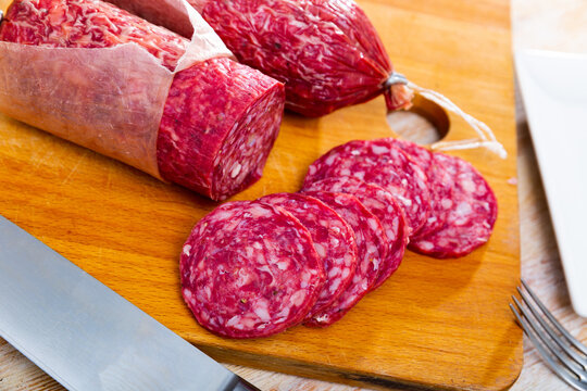 Appetizing traditional spanish salchichon sausage on wooden table