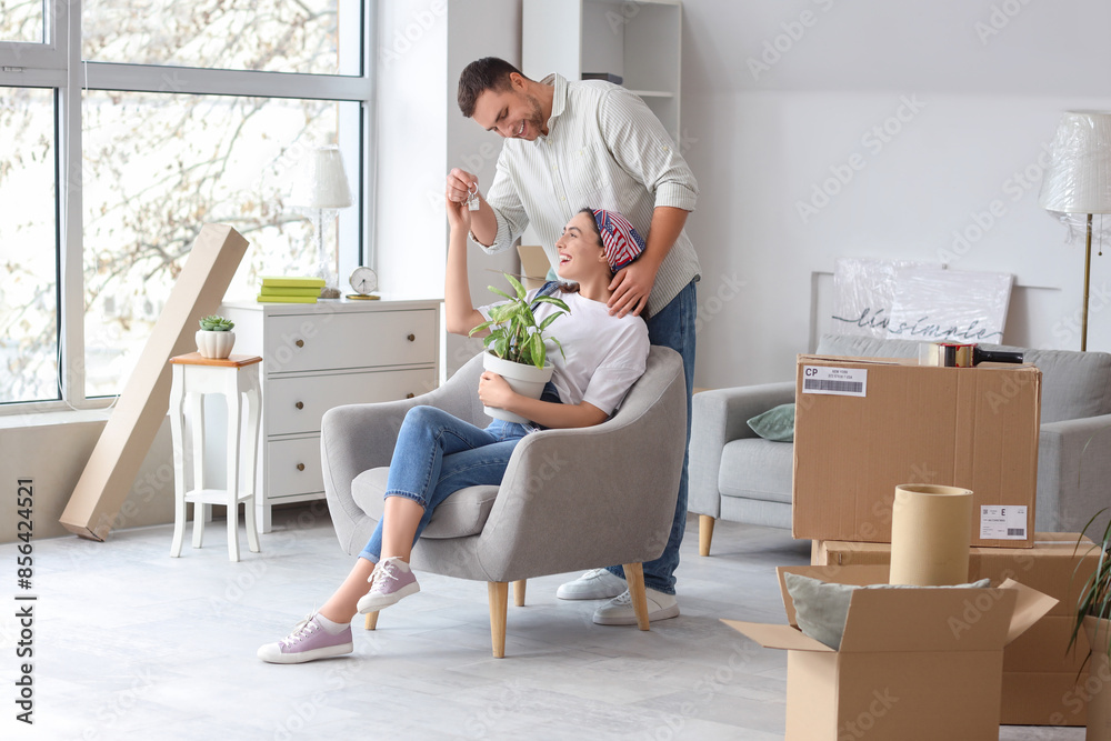 Sticker Happy young couple with keys from house in room on moving day