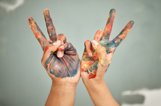 Paint, peace sign and hands of people for art with creativity, diy or hobby project together. Bonding, teamwork and artists with acrylic color stain for activity with hope, victory and unity gesture.