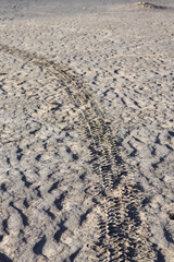 car tire tracks in black desert sand, perfect for wallpaper and backgrounds.