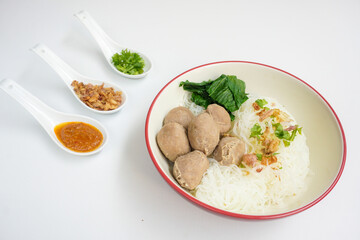 Bakso Meatballs and Rice Noodles with Soup Served Chili Sauce, Indonesia Food Style Popular Street Food served on bowl with chili sauce, chopped celery and fried onions sideview