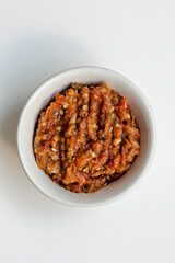Indonesia traditional cuisine sambal bawang or spicy garlic chili sauce served on a white bowl isolated on white background.
