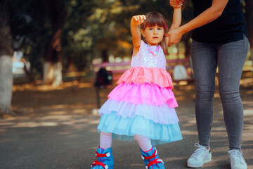 Girl Tries to Ride on Roller Skates for the First Time in the Park. Funny daughter about to fall on...