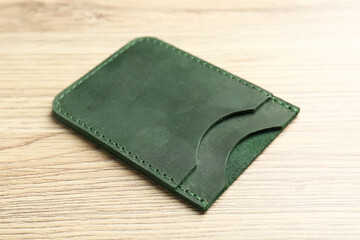 Leather business card holder on wooden table, closeup