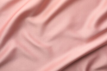 Crumpled pink silk fabric as background, top view