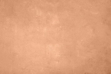 Stone surface of peach fuzz color, top view. Trendy shade of 2024 year