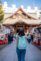 Fototapeta premium Unrecognizable young Latina woman takes a selfie on a bustling street in Tokyo, Japan, enjoying her travel experience.