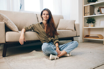 Obraz premium Relaxing in a Cozy Apartment: A Happy Woman Enjoying Modern Comfort on her Sofa
