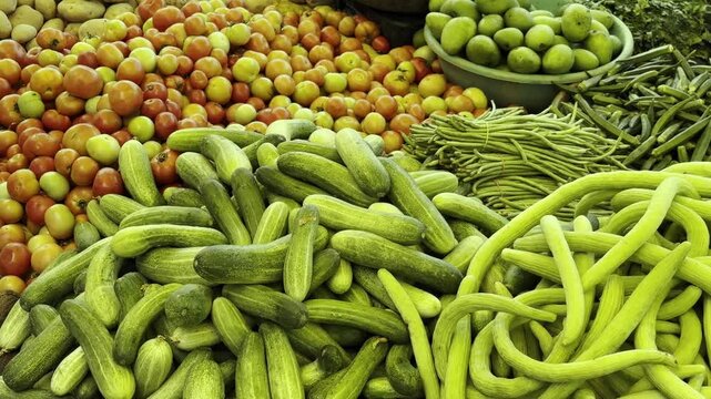 street vender is selling a variety of fresh vegetable like cucumber, tomato, potato, drumstick, Brinjal and bottle gourd in vegetable market, Farmers market, sabzi mandi