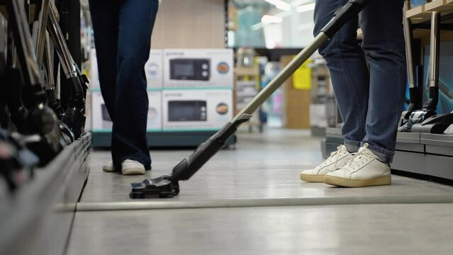 A man trying out vacuum cleaner in tech store. New technologies concept