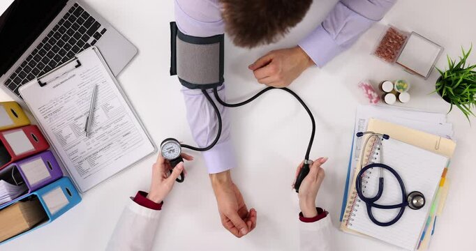 Doctor measures blood pressure using sphygmomanometer