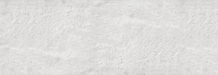 Large white grunge textured concrete wall background. The backdrop is a rough cement floor in gray...