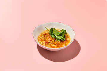 Gluten-Free Minestrone Vegetable Soup with Pasta in a Bowl on Pink Background