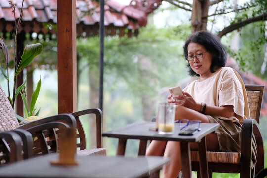 A woman sitting alone is busy with her smartphone