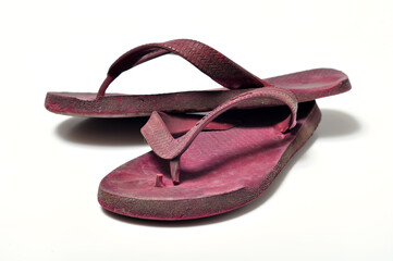 Worn and ugly flip flops on white background