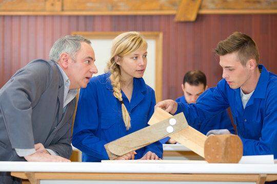 teacher and students in wood workshop - Powered by Adobe