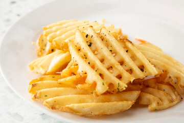 A view of a plate of waffle fries.