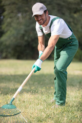 man raking fallen leaves in the garden