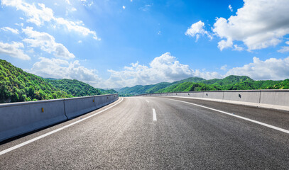 Asphalt highway road and green mountain with sky clouds natural background on sunny day. Car...