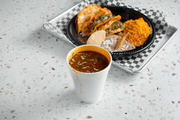 A view of a cup of consomme for beef birria tacos.