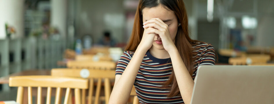 Asian young girl reading the book in library and closed her eyes to rest.
