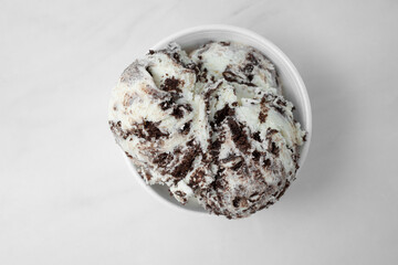A top down view of a cup with two scoops of cookies and cream ice cream.