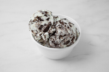 A view of a cup with two scoops of cookies and cream ice cream.