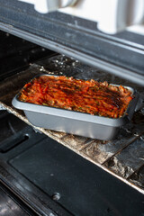 A view of a vegan meatloaf in a bread pan inside the oven.
