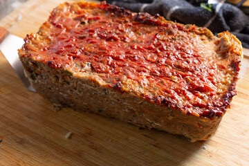 A view of ketchup applied to the top of a vegan meatloaf.