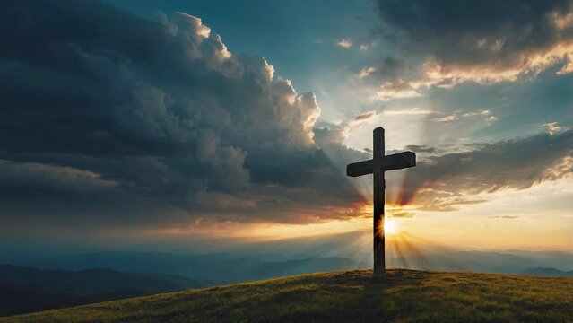 Christian cross on a hill with sunrise and moving clouds in the background