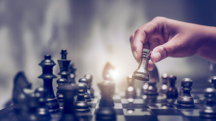 Businessman moving chess piece on chess board game concept for ideas and competition and strategy, business success concept, business competition planning teamwork strategic concept.	
