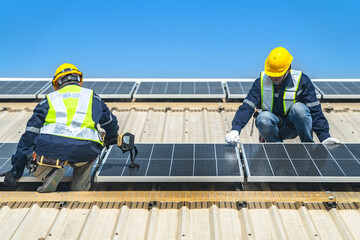 Worker Technicians are working to construct solar panels system on roof with sky and clound on...