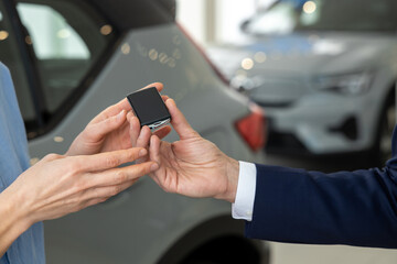 Close up picture of hands passing the car key