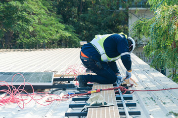 Worker Technicians are working to construct solar panels system on roof. Installing solar photovoltaic panel system. Men technicians carrying photovoltaic solar modules on roof.