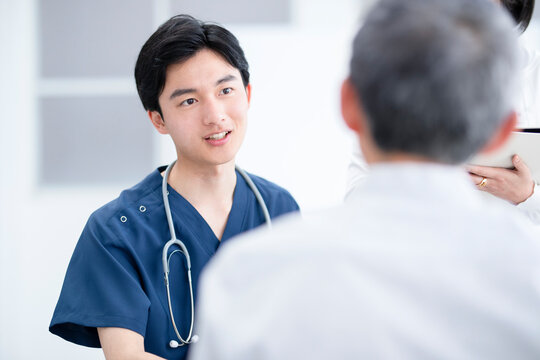 診察室で診察結果を説明する医師と患者